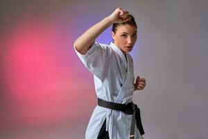 atletisch vrouw in traditioneel kimono is beoefenen karate in studio. foto