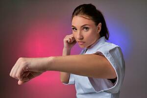 atletisch vrouw in traditioneel kimono is beoefenen karate in studio. foto