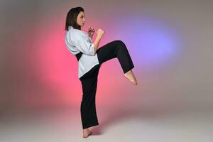 atletisch vrouw in traditioneel kimono is beoefenen karate in studio. foto