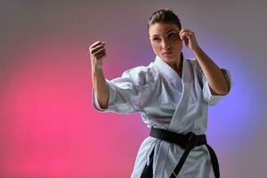 atletisch vrouw in traditioneel kimono is beoefenen karate in studio. foto