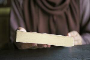 Dames hand- Holding een boek Bij bibliotheek foto