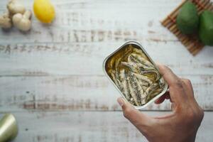 open blikje sardines op witte tegels achtergrond. foto