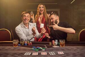 groep van een jong rijk vrienden zijn spelen poker Bij een casino. foto