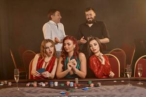 groep van een jong rijk vrienden zijn spelen poker Bij een casino. foto