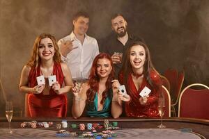 groep van een jong rijk vrienden zijn spelen poker Bij een casino. foto
