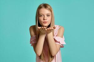 studio portret van een mooi meisje blond tiener in een roze t-shirt poseren over- een blauw achtergrond. foto