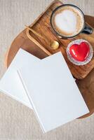 blanco boeken met hart vormig geglazuurd Valentijn taart in houten dienblad foto