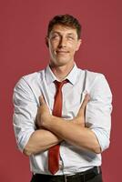 portret van een jong brunet Mens poseren in een studio tegen een rood achtergrond. foto