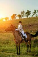 jong vrouw rijder met haar paard in avond zonsondergang licht. buitenshuis fotografie in levensstijl humeur foto