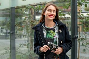 buitenshuis herfst glimlachen levensstijl portret van mooi jong vrouw, hebben pret in de stad met camera, reizen foto van fotograaf.