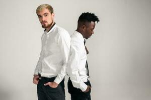 vrienden. twee jongens in wit overhemden en donker broek poseren in de studio Aan een wit achtergrond foto