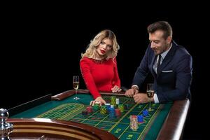 mooi en goed gekleed paar spelen roulette in de casino foto