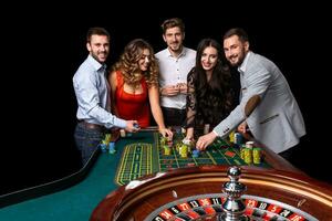 groep van jong mensen achter roulette tafel in een casino foto