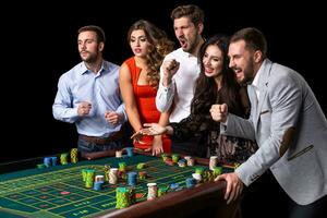 groep van jong mensen achter roulette tafel in een casino foto