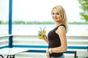 blond meisje Aan een zomer terras in een bar drankjes cocktail foto