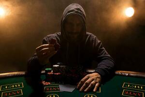 portret van een professioneel poker speler zittend Bij poker tafel foto