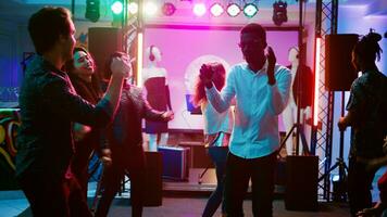 gelukkig Mens dansen met mensen Bij club, hebben pret Aan funky koel muziek- Bij discotheek. jong persoon feesten en jumping in de omgeving van Aan dans vloer, sociaal bijeenkomst Bij bar. handheld schot. foto