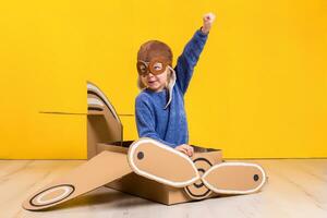 weinig dromer meisje spelen met een karton vliegtuig. jeugd. fantasie, verbeelding. foto