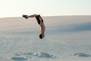 Mens studie parkour Aan hun eigen. acrobatiek in de zand foto