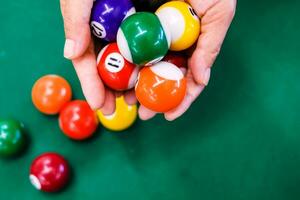 hand- Holding kleurrijk biljart bal gebied Aan groen flanel Aan snooker tafel, snooker is foto