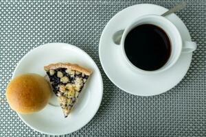 brood met bosbes kaas taart met zwart koffie Aan tafel foto