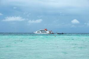 veerboot schip met houten lang staart boot Aan turkoois zee foto