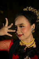 een Indonesisch danser poseren met haar mooi en mooi handen terwijl vervelend bedenken Bij nacht foto