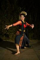 een Javaans danser dansen met goud accessoires en een gezicht vol van bedenken foto