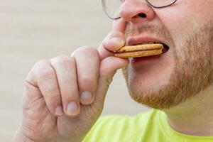 ai gegenereerd Mens geniet koekje in schuldig genoegen foto