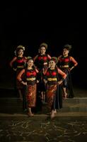 een groep van dansers staan en verenigen in rood kostuums dat tonen eenheid foto