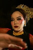 een Aziatisch danser verbaast de publiek in een cultureel kunsten prestatie in rood kostuums foto
