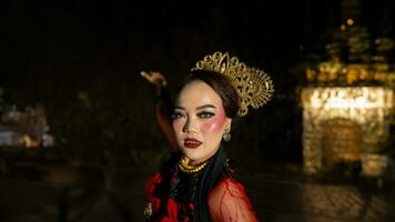 een Indonesisch danser met gelaats uitdrukkingen dat straalt uit schoonheid en geluk dansen en boeit de publiek foto