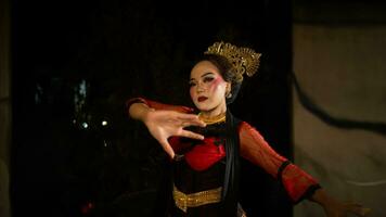 een Indonesisch danser zoekt uit en nodigt uit de publiek naar worden gedragen weg in een cultureel prestatie foto
