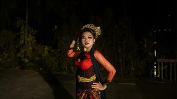 een Indonesisch danser met sprankelend stadium lichten dat creëren de indruk van luxe en elegantie foto