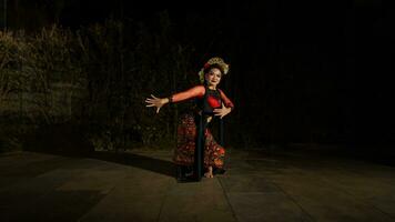 een Aziatisch danser dansen in voorkant van de werf in een rood kostuum foto