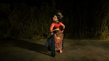 een Indonesisch danser looks vol van enthousiasme en shows zijn moed naar Actie en dans foto