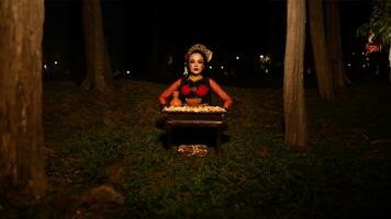 een vrouw danser wie looks mooi in een rood kostuum presteert een ritueel dat straalt uit een aura van schoonheid en zuiverheid foto