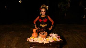 een vrouw danser zit sierlijk en begint haar ritueel in voorkant van mooi aanbiedingen foto