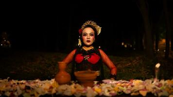 een vrouw danser wie looks mooi in een rood kostuum presteert een ritueel dat straalt uit een aura van schoonheid en zuiverheid foto