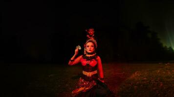 een vrouw danser in een rood kostuum za in de stilte van de nacht welke versterkt de droefheid foto