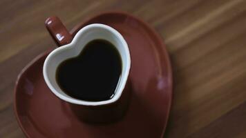 vrouw gemaakt koffie in hart mok. concept. mooi rood hartvormig mok met donker koffie. romantisch hartvormig mok met koffie Aan romantisch dag foto