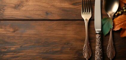 ai gegenereerd mes en vork met doorbladert en bladeren Aan een houten tafelblad foto