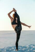 geschiktheid yoga vrouw uitrekken Aan zand. fit vrouw atleet aan het doen yoga houding. foto