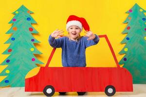 kind in rood Kerstmis auto. Kerstmis vakantie concept foto