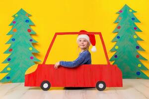 kind in rood Kerstmis auto. Kerstmis vakantie concept foto