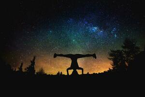 yoga en dansen silhouet Bij de nacht sterrenhemel lucht achtergrond. foto