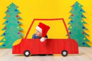 kind in rood Kerstmis auto. Kerstmis vakantie concept foto