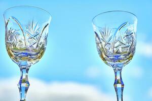 twee schijnend kristal wijn bril en blauw lucht foto