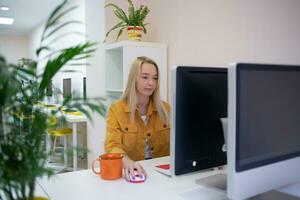 jong vrouw zit Bij een computer in de kantoor. afgelegen werk concept foto