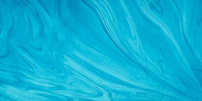 blauw vloeistof verf Aan een oppervlakte met golven foto